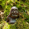 Carved stone figure of a face on a mossy background
